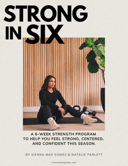 A woman in black athletic wear sits on a gym mat with dumbbells and a plant nearby. Text reads STRONG IN SIX, promoting Strong in Six | Sienna Mae Gomez 6-Week Workout Program by Sienna Mae Gomez.