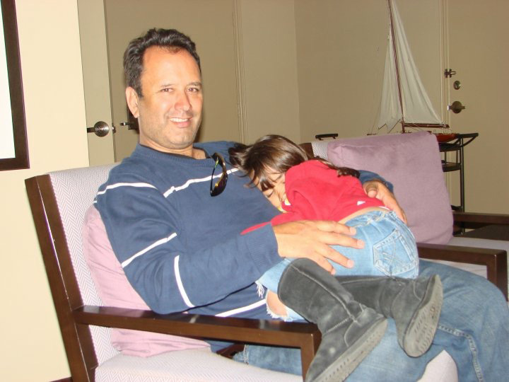 Father and child sitting together in a chair with child in his lap