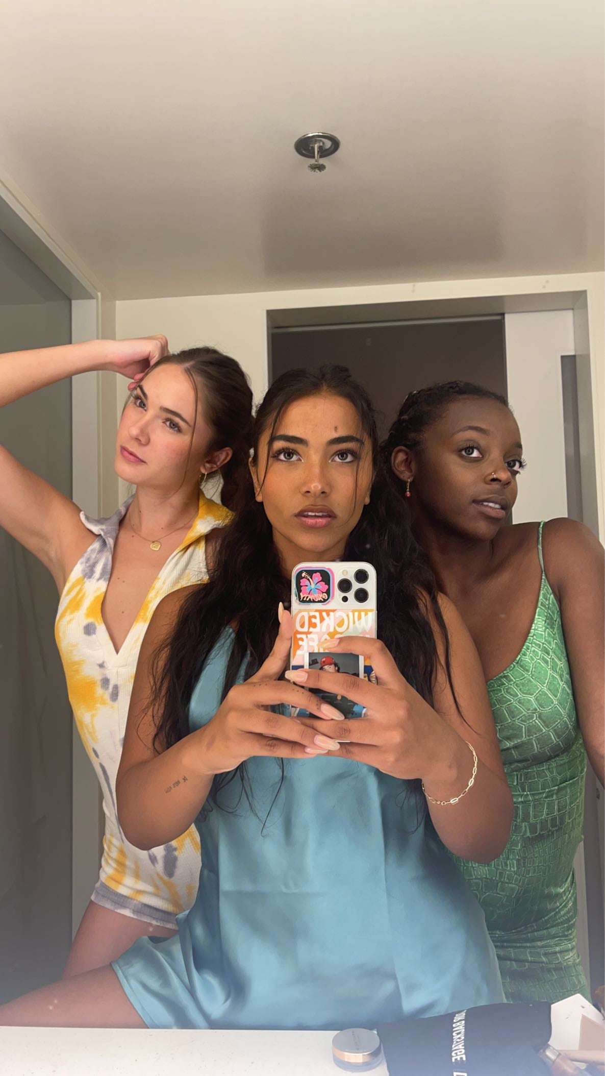 Three girls pose in the mirror