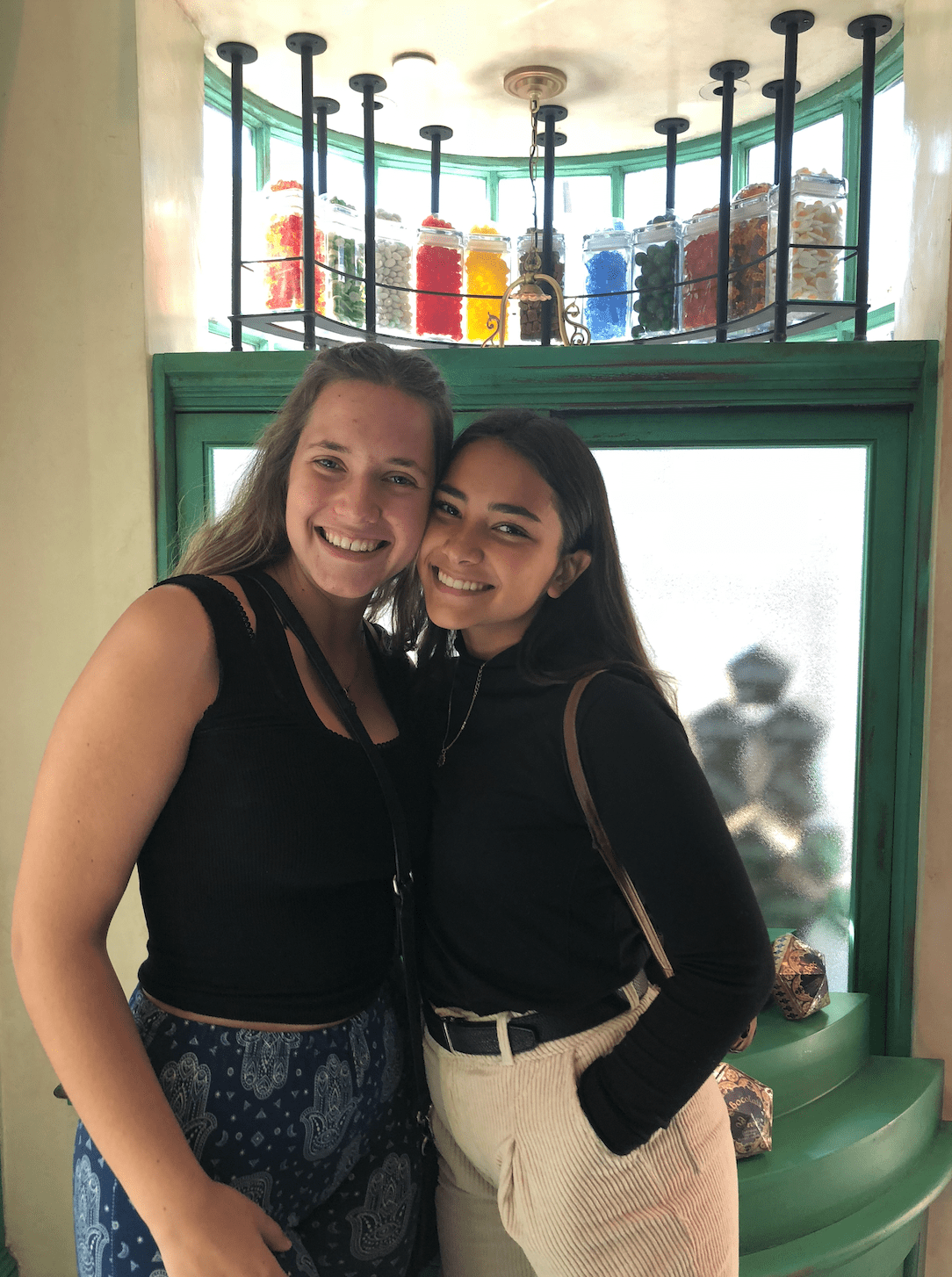 Two girls post together in front of glass display