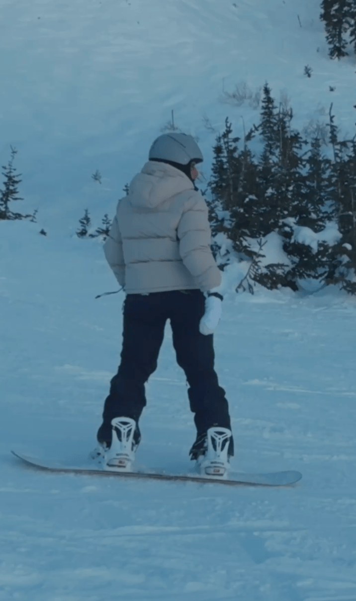 Girl snowboarding in beige jacket